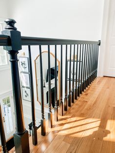 the stairs are lined with black railings and wood flooring in an empty room