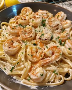 pasta with shrimp and parmesan cheese in a bowl on a marble table top