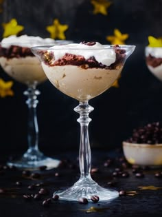 three desserts in glasses on a table with coffee beans and stars around the bowl