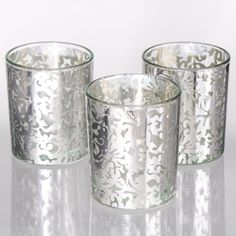 three silver glass cups sitting next to each other