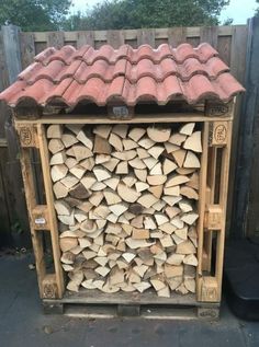 a large pile of firewood in a wooden storage box with red roof tiles on top