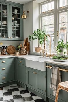 a kitchen filled with lots of green cupboards and counter top space next to a checkered floor