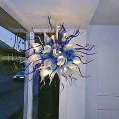 a blue and white chandelier hanging from the side of a building next to a window