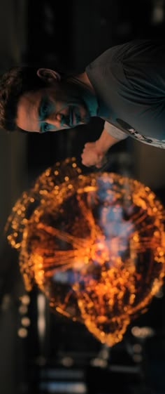 a man standing in front of a large object with many lights on it's sides