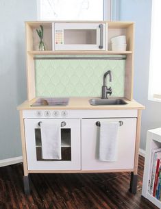 a toy kitchen with sink, stove and microwave