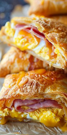 three breakfast pastries stacked on top of each other with ham and egg in the middle