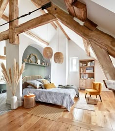 a bedroom with wood floors and exposed beams in the ceiling, along with a bed