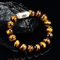 Tiger Eye Premium Bead Bracelet with round 10 millimeter beads combined with a silver logo magnetic clasp. Comes with a premium leather logo box. You will not find the quality of beads I use which are 5A quality rated, the custom silver beads and high quality custom made silver clasp I use for my bracelets at any where close to the value I offer. I use the absolute best stone bead gems there is, my custom made silver beads are solid and I double string my bracelets with a thick gauge stainless s Brown Gemstone Beaded Bracelets, Brown Beaded Bracelets With Spacer Beads, Brown Bracelets With 8mm Beads, Brown 8mm Beaded Round Bracelets, Brown Bracelet With 8mm Round Beads, Brown Round Bracelets With 8mm Beads, Polished Round Brown Beaded Bracelets, Mens Bead Bracelet, Tiger Eyes