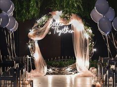 an outdoor wedding setup with balloons and lights