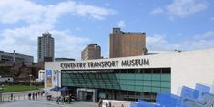 people are walking around in front of a building with a sign that says country transport museum