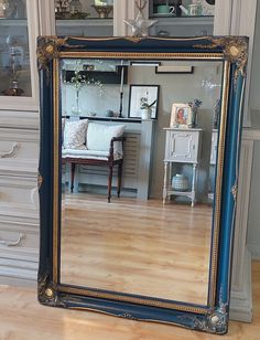 a large mirror sitting on top of a hard wood floor