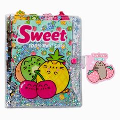 a small notebook with some fruit on it and a sticker attached to the cover