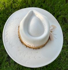 "Discover the rugged charm of our Burned Western Hat. This unique, handcrafted cowboy hat features a distressed look, giving it a vintage, well-worn appeal perfect for Western enthusiasts and fashion-forward individuals." Features: Handcrafted Design: Each hat is meticulously burned and distressed to achieve a one-of-a-kind look. Premium Materials: Made from high-quality materials for durability and comfort. Unique Aesthetic: The burned finish adds a distinctive vintage style that sets it apart. Benefits: Custom and Unique: No two hats are exactly alike due to the handcrafted burning process. Versatile Style: Ideal for Western-themed events, country outings, or adding a rugged touch to everyday outfits. Durable Construction: Designed to withstand wear and tear while maintaining its unique Country Style Cream Hat Bands For Western-themed Events, Cream Country Style Hat Bands For Western-themed Events, Western Style Wedding Hat With Flat Brim, Western Flat Brim Wedding Hat, Western Style Flat Brim Wedding Hat, Country Style Festival Hat Bands With High Crown, Western Fedora Hat For Wedding, Handmade Western Felt Hat For Kentucky Derby, Western Style Handmade Felt Hat For Kentucky Derby