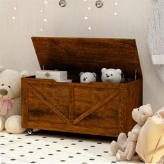 two teddy bears sitting next to a wooden box with baby items in it's lap