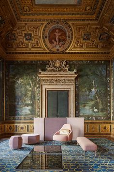 an ornate room with pink chairs and paintings on the walls