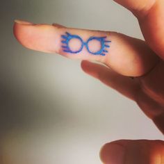 a person's finger with a small tattoo on it