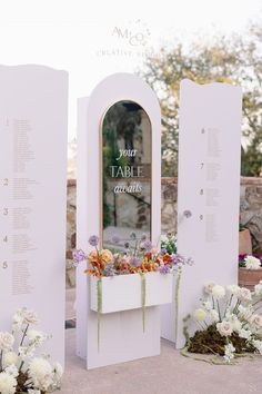 an outdoor table with flowers in it and the words your table are written on the wall