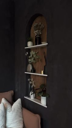 a living room filled with furniture and plants on top of the shelves next to each other