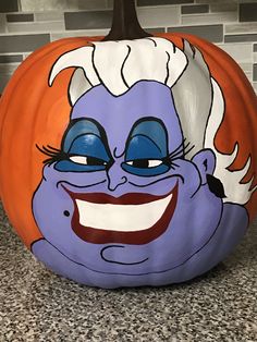 a painted pumpkin with an evil face on it