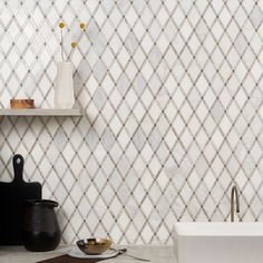 a white sink sitting next to a wall mounted faucet