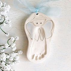 a ceramic ornament with an angel on it next to some baby's breath flowers