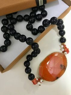 ✔️Mediterranean style necklace! Made with string of individually knotted onyx pearls and interrupted by an oval orange agate medallion surrounded by coral chips. Perfect jewel to enrich a casual outfit or for an important moment! ✔️DETAILS: 🟩 Materials: Onyx Agate Coral 🟧🟧Dimensions: Necklace length: 70/28" cm Pearl Diameter: 1cm/4"  Nickel and lead free 🔔 Artisan Jewelry My jewels are strictly handmade so each of them is truly unique because there may be slight differentiations which in the Luxury Adjustable Orange Necklace, Luxury Handmade Carnelian Beaded Necklaces, Orange Agate, Mediterranean Style, Outfit Casual, Artisan Jewelry, Favorite Jewelry, Onyx, Necklace Lengths