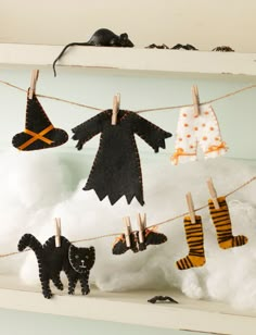 halloween decorations hanging from clothesline with black cats and witches