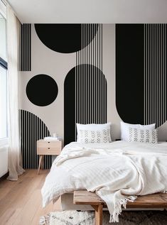 a bedroom with black and white striped wallpaper, a bed in the foreground