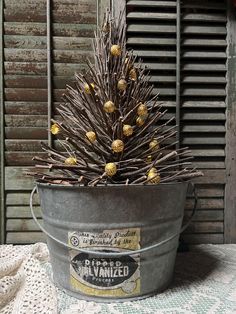 a metal bucket filled with yellow flowers on top of a table