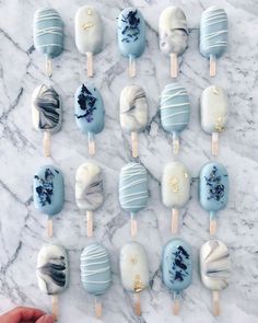 several blue and white lollipops sitting on top of a marble counter