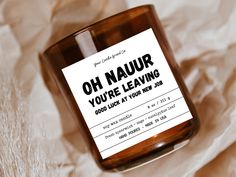 a candle with a label that says oh nauur you're leaving good luck at your new job