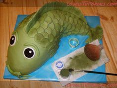 a green fish cake sitting on top of a blue plate with an acrylic brush