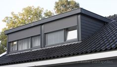 the roof of a house with two windows and a black shingled dormer on it