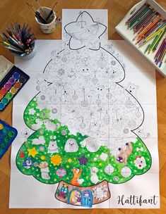 a christmas tree is on the floor with crayons and markers