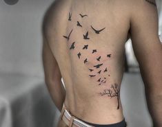 a man with a tree and birds tattoo on his back