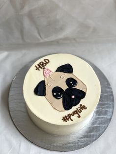 a birthday cake with a pug on it's side sitting on a table