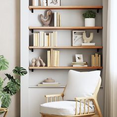 a white chair sitting in front of a book shelf filled with books