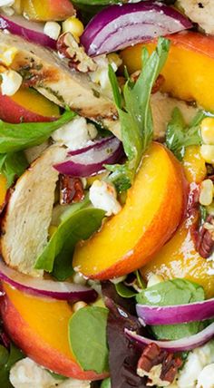 a salad with chicken, peaches, and spinach on it is ready to be eaten