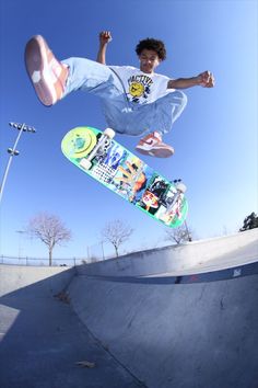 a young man riding a skateboard up the side of a cement ramp at a skate park