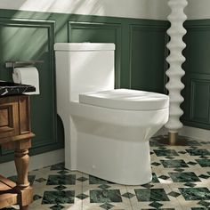 a white toilet sitting in a bathroom next to a wooden vanity and green painted walls