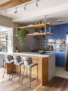 a kitchen with blue cabinets and white counter tops next to an island in front of a refrigerator