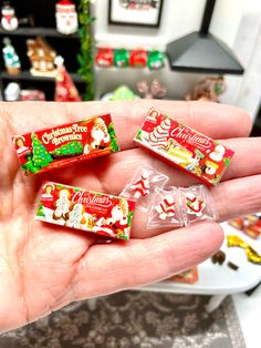 someone is holding three christmas candy bars in their hand, and they are all wrapped up