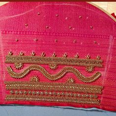 the back of a pink jacket with gold thread work