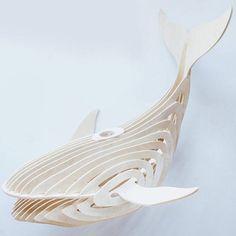 a wooden model of a whale on a white background with the tail cut out to show it's intricate design