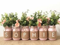 pink painted mason jars with flowers in them that spell out the word, sophiie