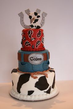 a three tiered cake decorated with cow print