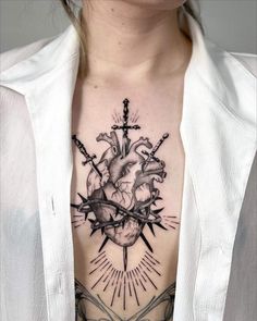 a woman's chest with a heart and cross tattoo on it