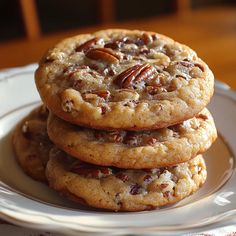 three pecan cookies stacked on top of each other in a white plate with a red and white checkered tablecloth