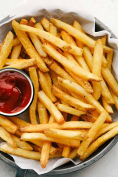 french fries with ketchup in a basket on a table