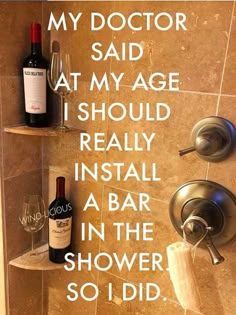 a wine bottle sitting on top of a shelf next to a shower faucet